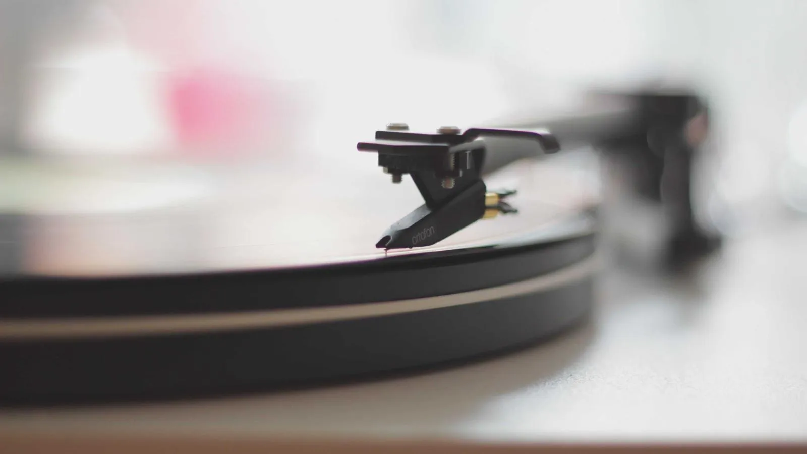 Close-up of a turntable tonearm resting on a vinyl record